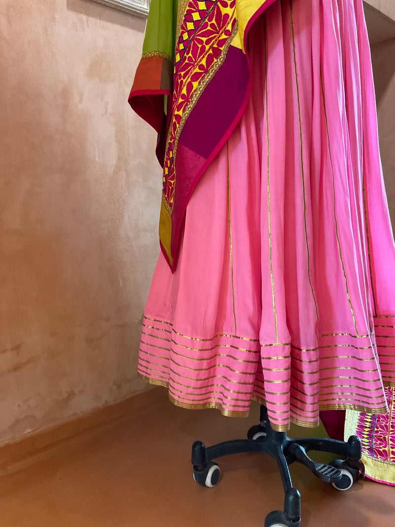 Photo of twirling bride in bright pink lehenga with green dupatta